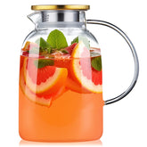 Jarra DOPUDO de vidrio con gradiente azul y tapa dorada, ideal para presentar bebidas.