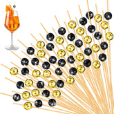 Pinchos Hushee con bola disco dorada y negra, ideales para cócteles y aperitivos.