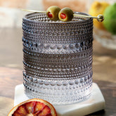 Vasos Kate Aspen con abalorios y textura gris humo, ideales para cócteles.