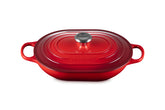 La Le Creuset Cazuela Oval Esmaltada con Tapa en Cerise lista para servir en la mesa.