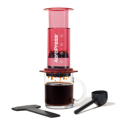 AeroPress claro rojo muestra el cuerpo transparente para ver la extracción del café.