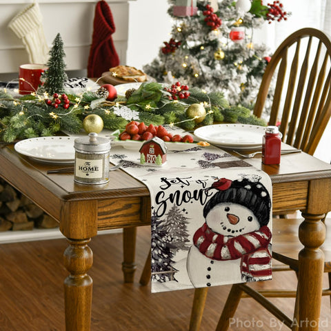 Mantel Artoid Mode con muñeco de nieve negro para decorar la mesa festiva.