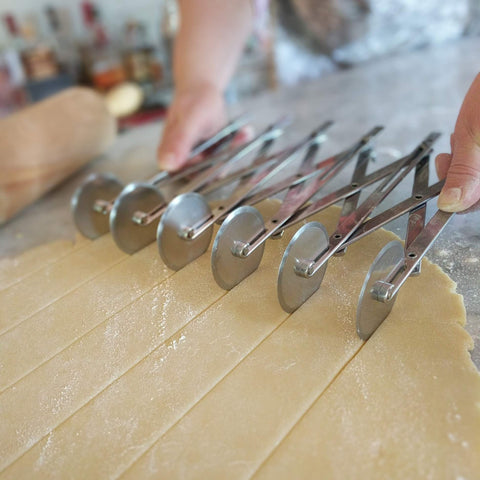 Cortador Ateco con ruedas ajustables para espaciado preciso entre porciones.