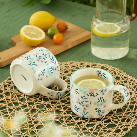 Taza artesanal DELIGHTS GALORE blanca con diseño floral azul y morado para beber en casa