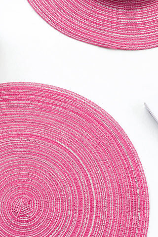 Floroom manteles trenzados en rosa baya, añaden textura y estilo a la mesa.