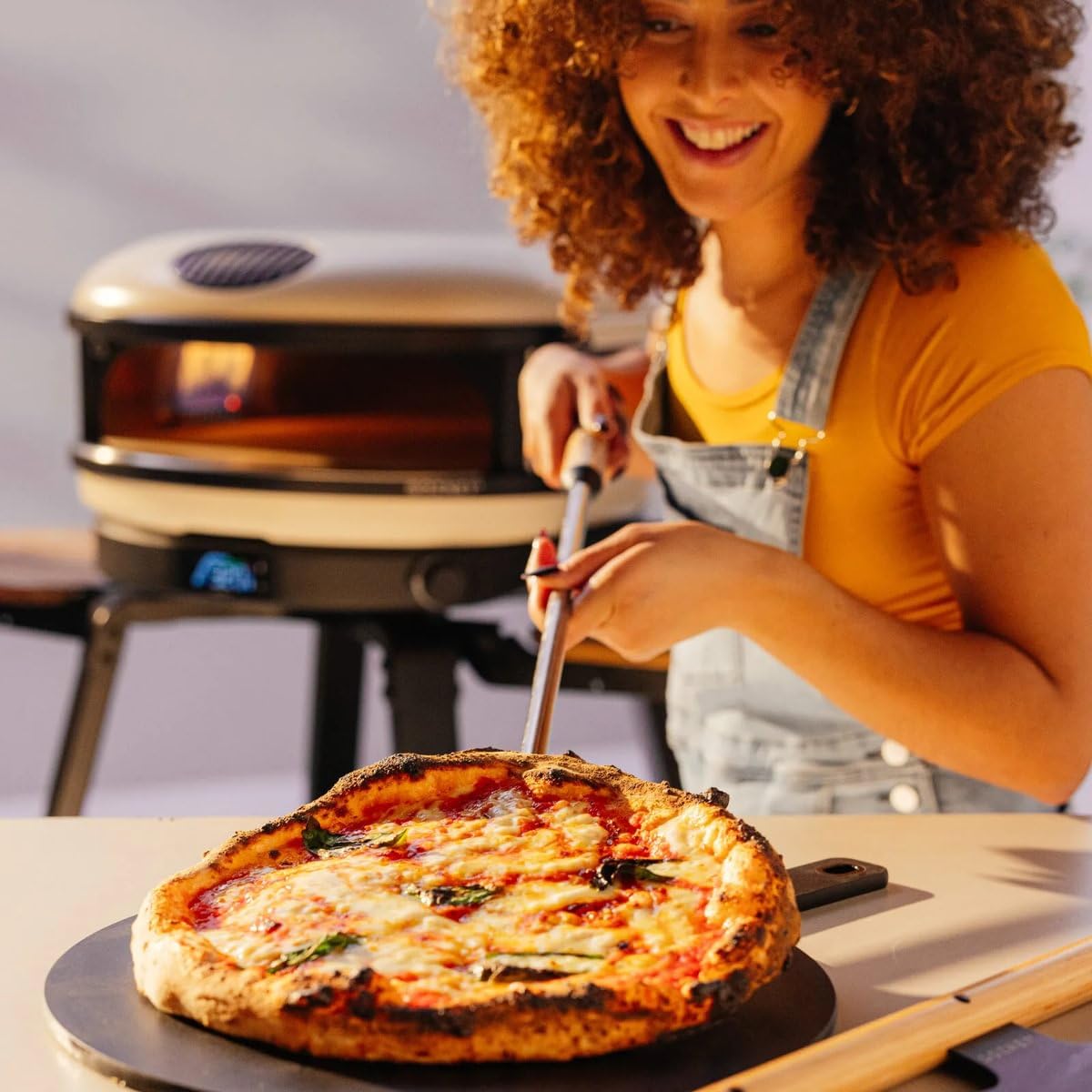 Gozney pala para horno facilita colocar y servir pizzas calientes con precisión.