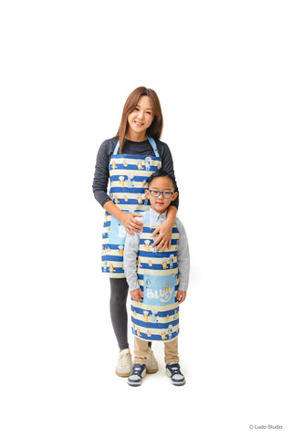 Delantal Handstand Kitchen para niño con rayas azules, perfecto para aprender cocinando juntos.