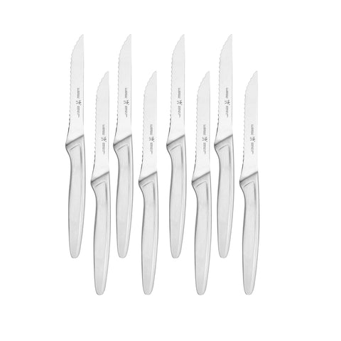 Cuchillos HENCKELS para bistec de 8 piezas sobre una mesa, filo de precisión.