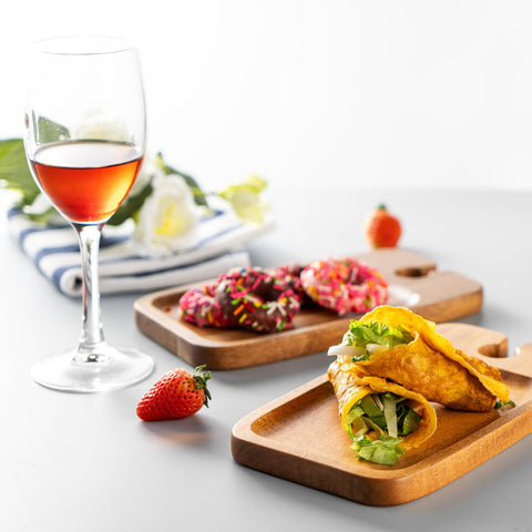 Presentación elegante de queso y vino en tablas pequeñas.