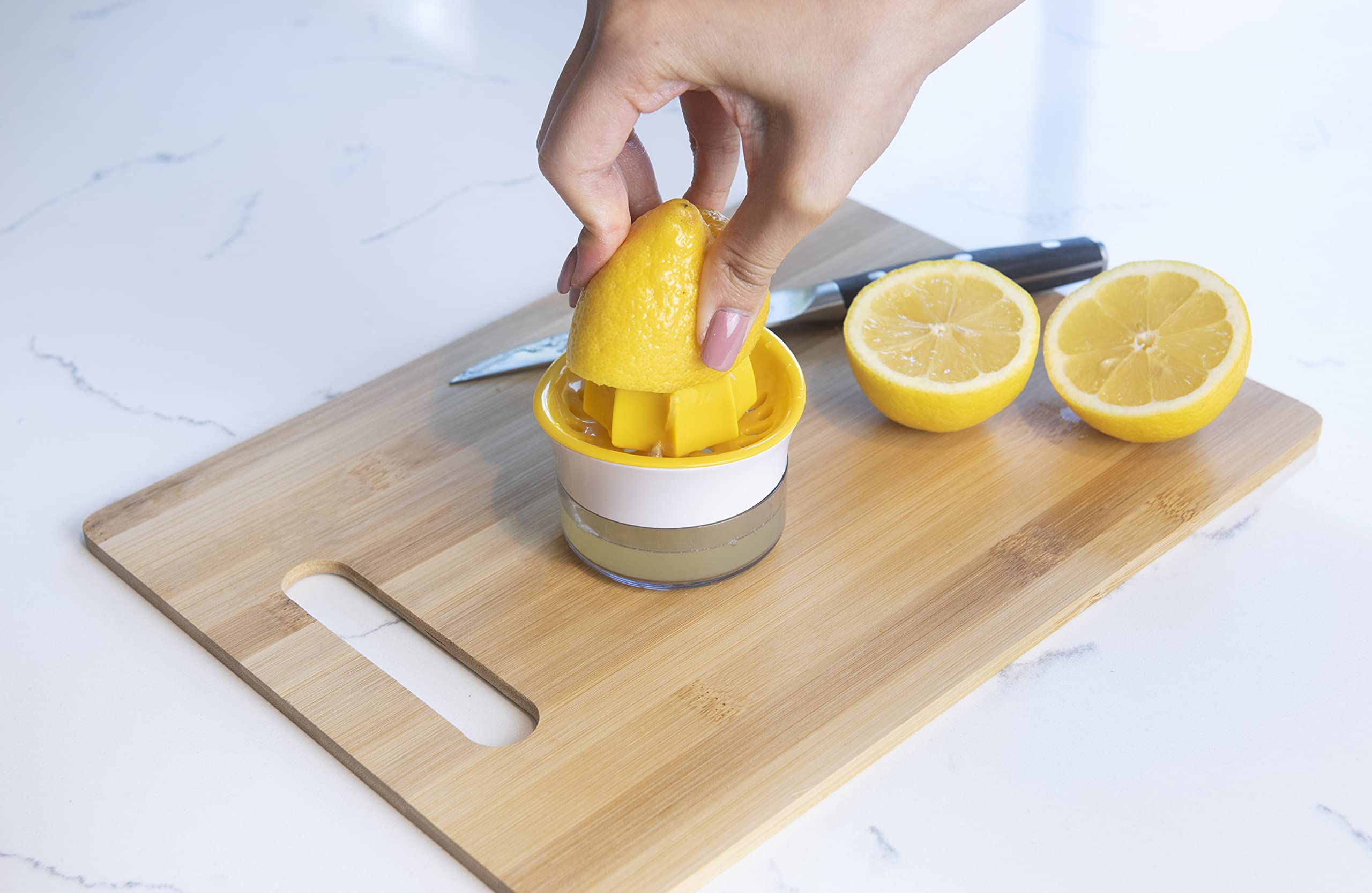 Joie exprimidor-reamer amarillo captura jugo sin semillas en cítricos.