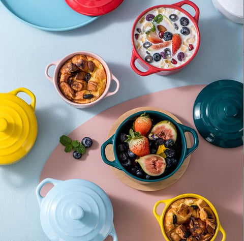 Jucoan ramequín de porcelana con tapa y asa; ángulo trasero muestra tono rojo.