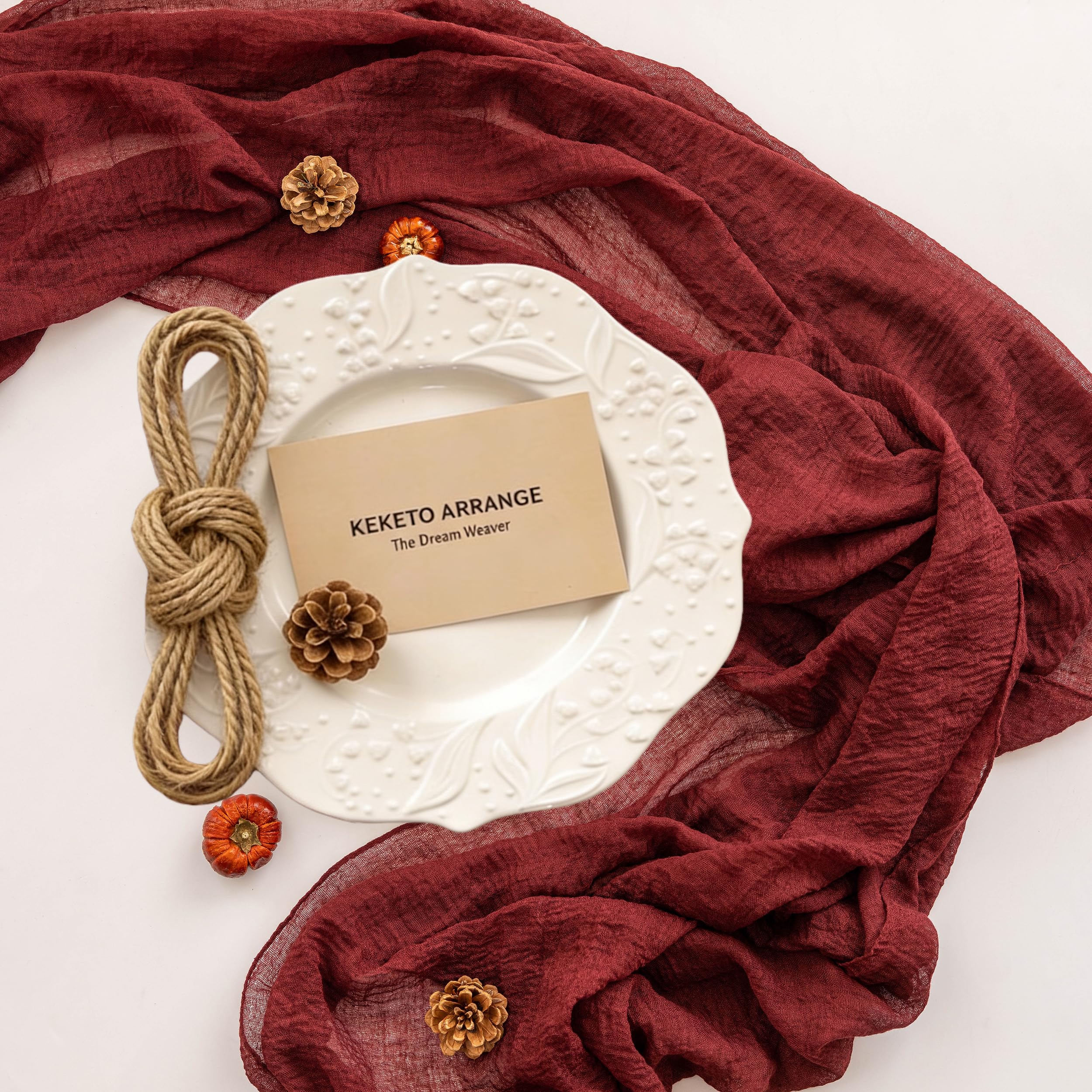 Primer plano de Keketoarrange cinta de mesa burdeos con caída elegante.