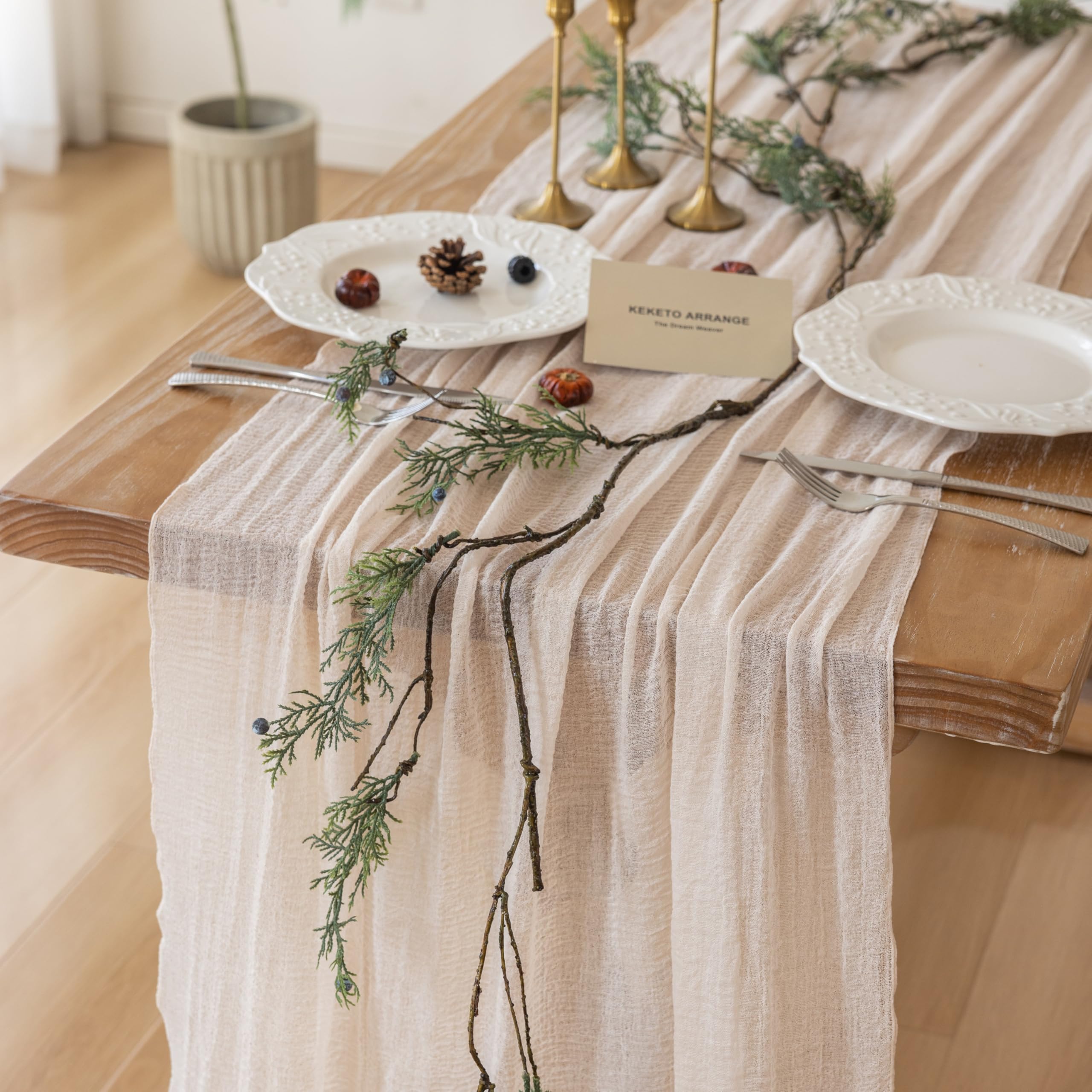 Mantel Keketoarrange de gasa beige sobre mesa para un ambiente cálido y elegante