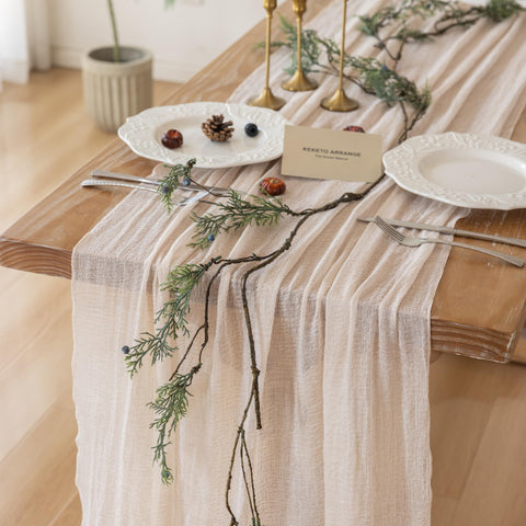 Mantel Keketoarrange de gasa beige sobre mesa para un ambiente cálido y elegante