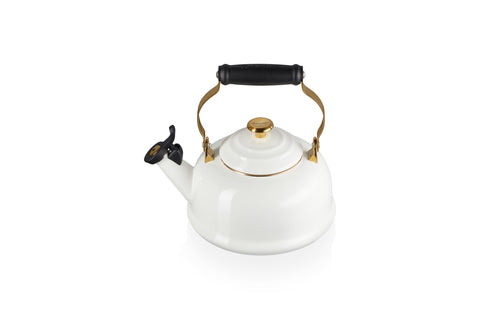 Hervidor Le Creuset con esmalte blanco y detalle dorado para hervir agua rápidamente.