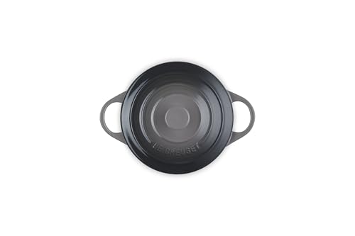 Manos sosteniendo las asas de la Le Creuset para servir con seguridad.