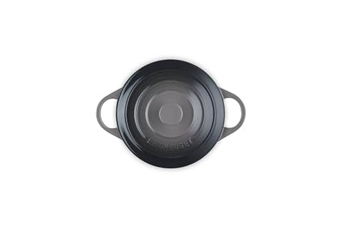 Manos sosteniendo las asas de la Le Creuset para servir con seguridad.