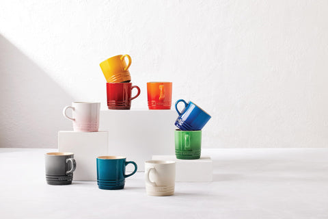 Taza London de Le Creuset en manos con vapor suave.
