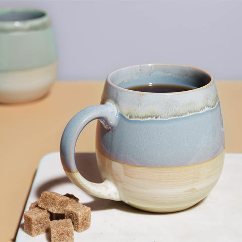Taza cerámica LIFVER con forma huevo azul, mango cómodo para un agarre estable.