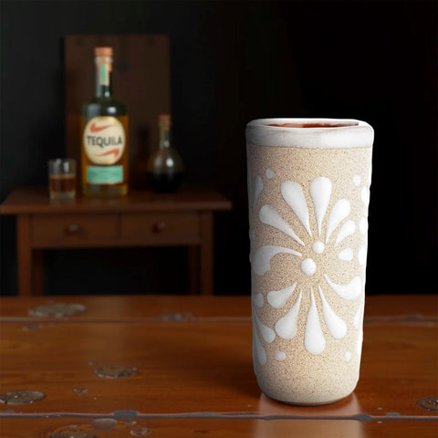Vasos decorativos MEXTEQUIL con patrón blanco, embellecen la barra.