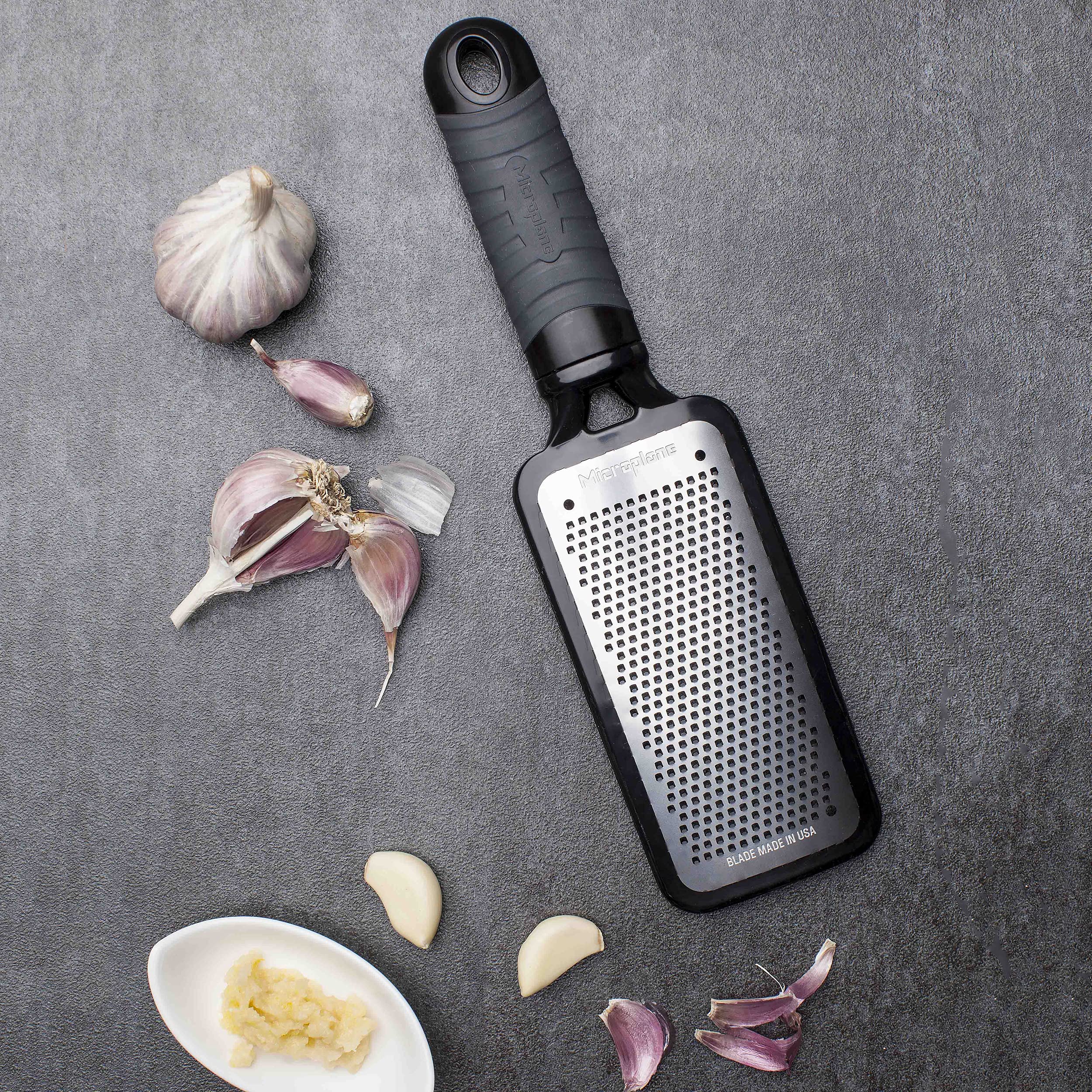Rallado ajo y jengibre con Microplane Home Series, libera aroma intenso para salsas.