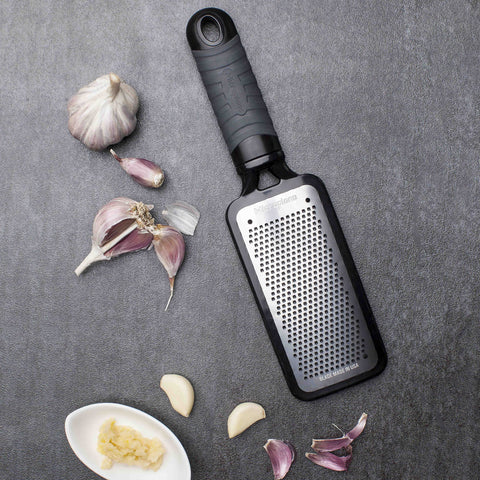 Rallado ajo y jengibre con Microplane Home Series, libera aroma intenso para salsas.