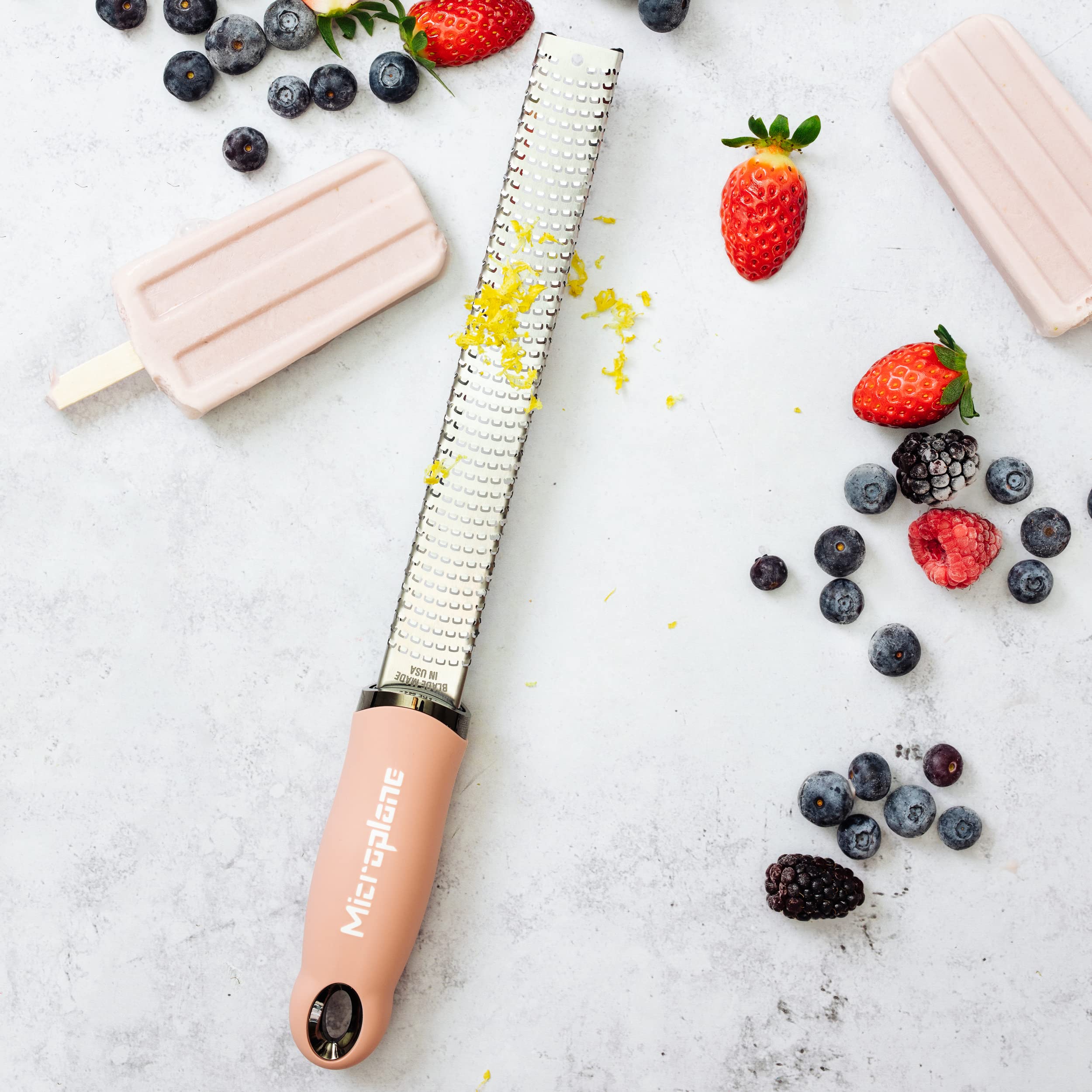 Microplane rallador rosado rallando canela para postres perfumados.