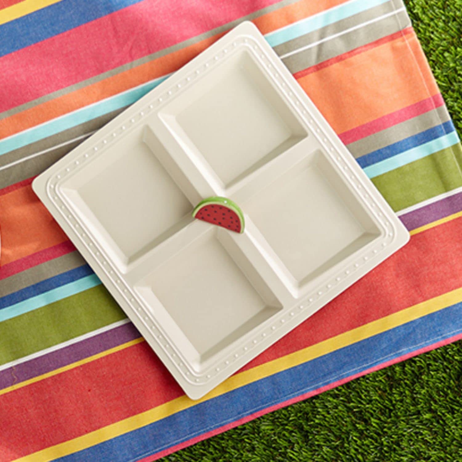 Nora Fleming mini en primer plano sobre la mesa de verano.