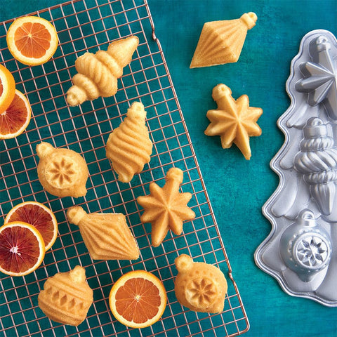 Nordic Ware pan-cakelet seis cakelets, detalle ornamentado para mesa festiva.