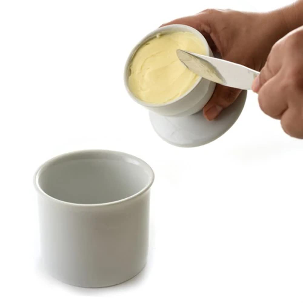 Tapa invertida con agua cubriendo la mantequilla, sello para conservar la frescura.