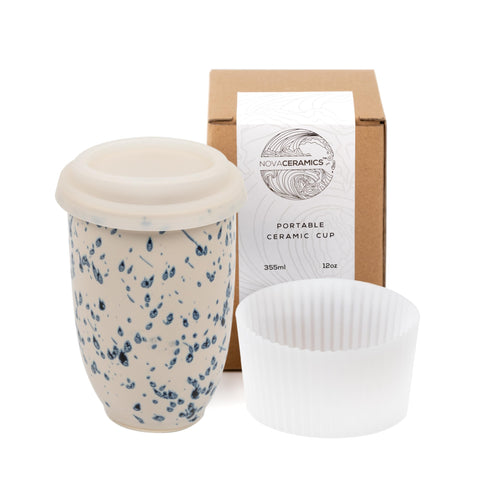 NOVA CERAMICS Taza Orchid, vista frontal blanca con salpicaduras azules, ideal para café.