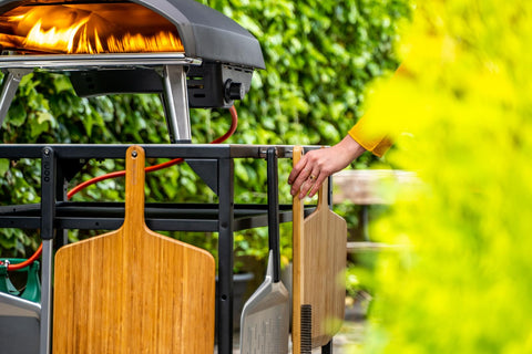Diseño ergonómico Ooni con mango de madera para un agarre cómodo.
