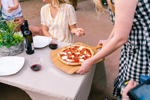 Ooni pala como tabla para servir pizza presentable en mesa