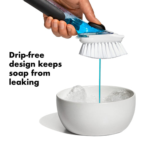 La brocha dispensadora OXO muestra cerdas de nailon duraderas para limpieza suave.