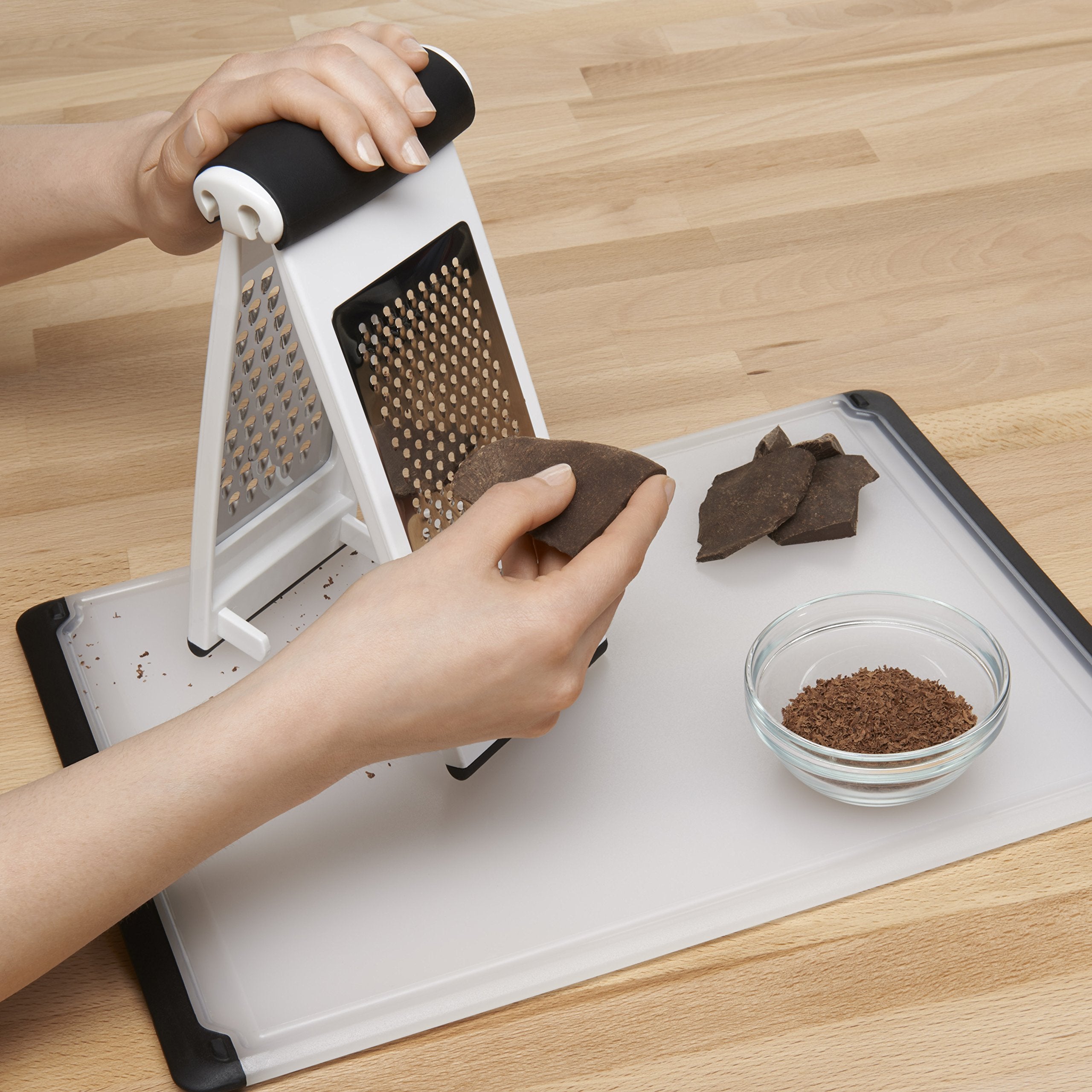OXO Good Grips Multi Grater funcionando sobre un cuenco para rallado limpio.