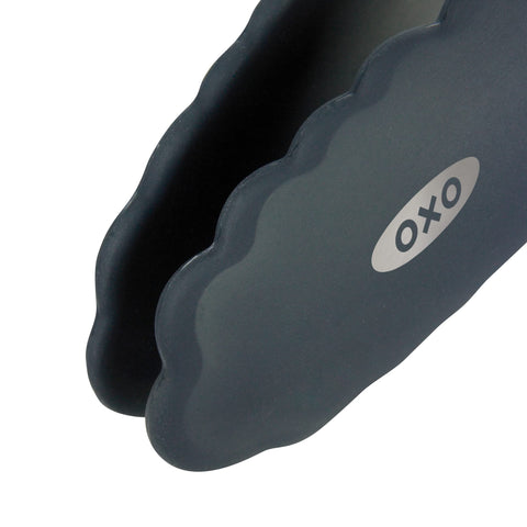 Pinzas OXO de acero inoxidable con mango ergonómico para agarre cómodo.
