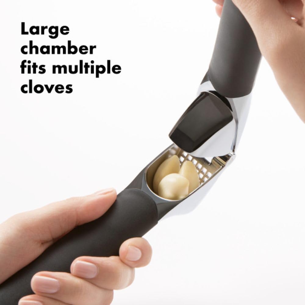 Prensador OXO con limpiador integrado para eliminar pieles fácilmente.