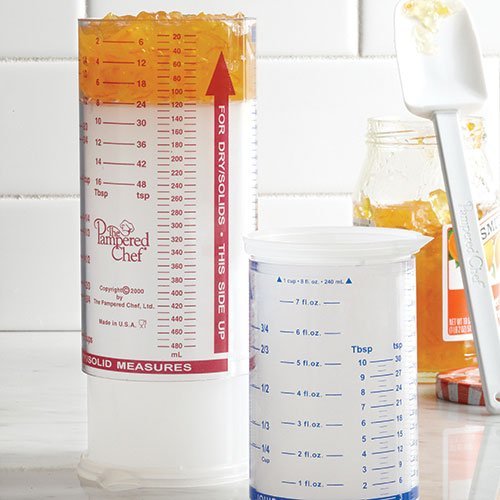 Pampered Chef 2225, diseño de émbolo ajustable para medir líquidos y sólidos con precisión.