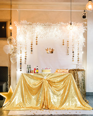 Mantel dorado PartyDelight 60x102 en mesa de banquete con brillo suave