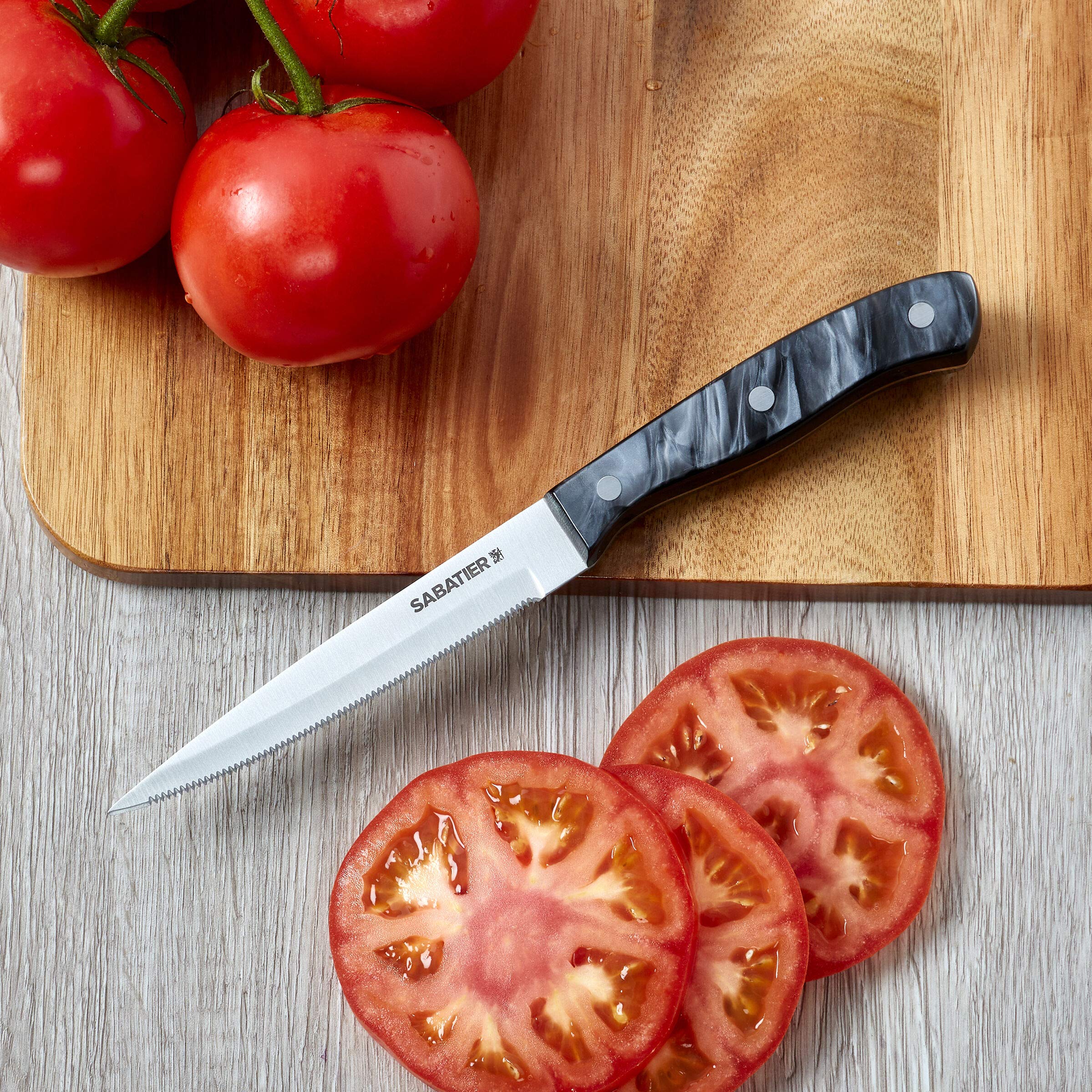 Sabatier cuchillo en uso cortando tomate mostrando control y rebanadas limpias