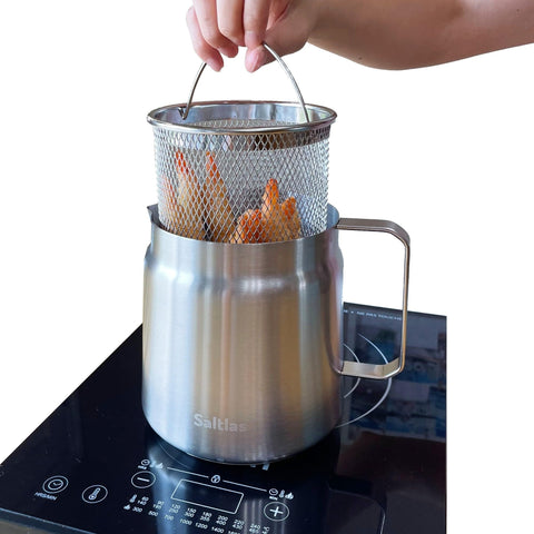 Saltlas olla frita profunda con cesta, lista para papas crujientes.