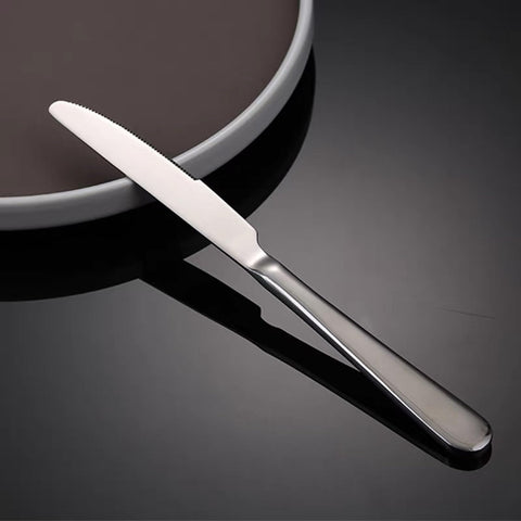 Corte de pan artesano con cuchillos para mantequilla, acero inoxidable.