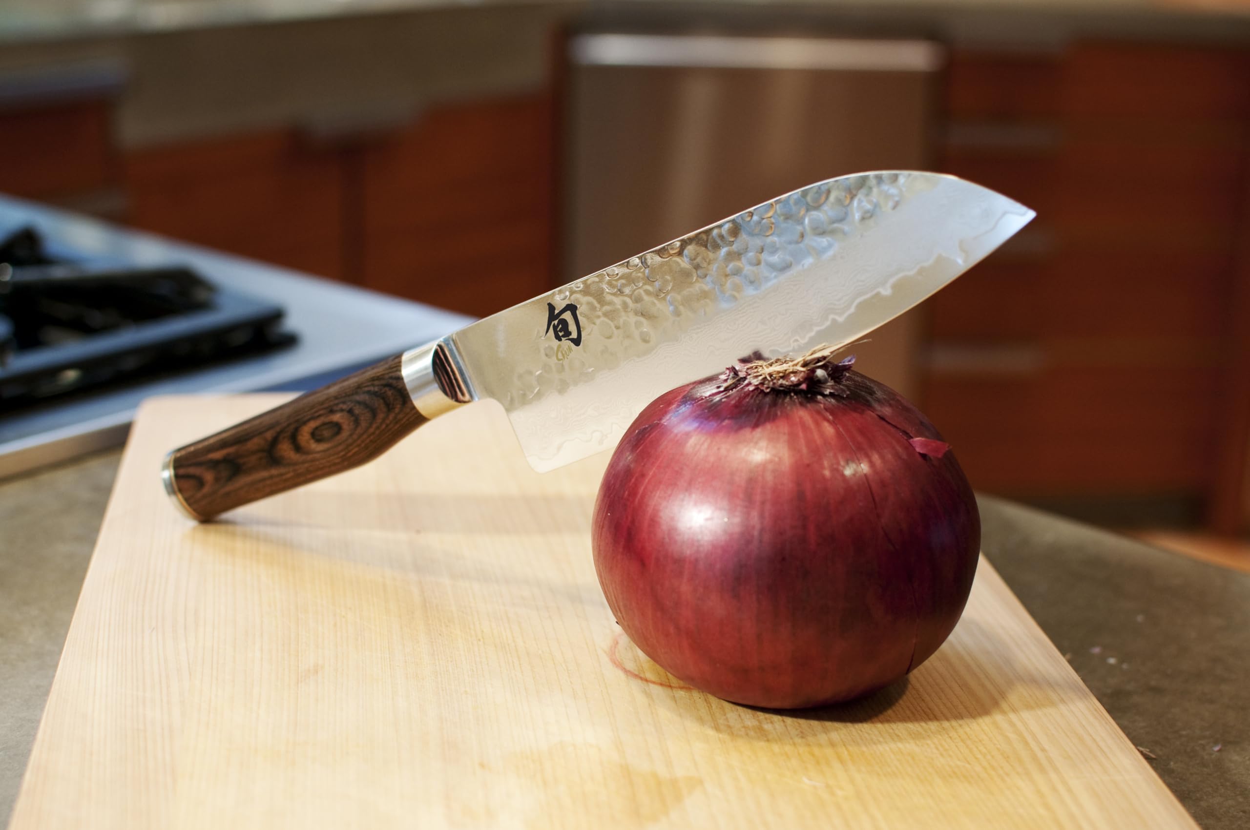 Shun Premier Santoku con acabado hammered tsuchime facilita liberar los alimentos al cortar.
