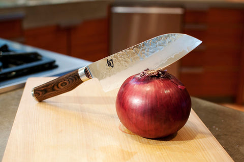 Shun Premier Santoku con acabado hammered tsuchime facilita liberar los alimentos al cortar.