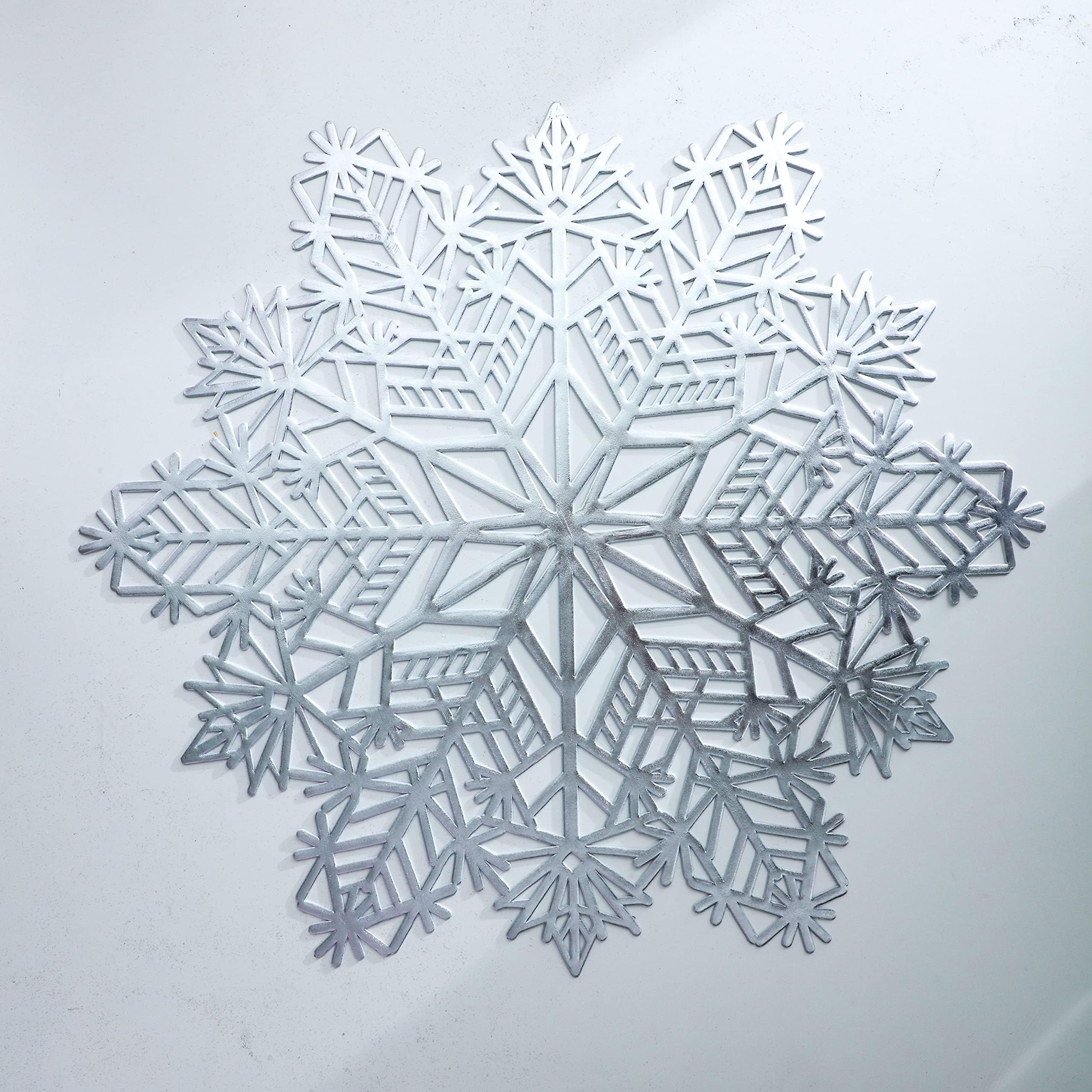 Detalle de copo navideño en vinilo laminado plateado, fácil de limpiar y duradero.