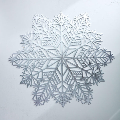 Detalle de copo navideño en vinilo laminado plateado, fácil de limpiar y duradero.
