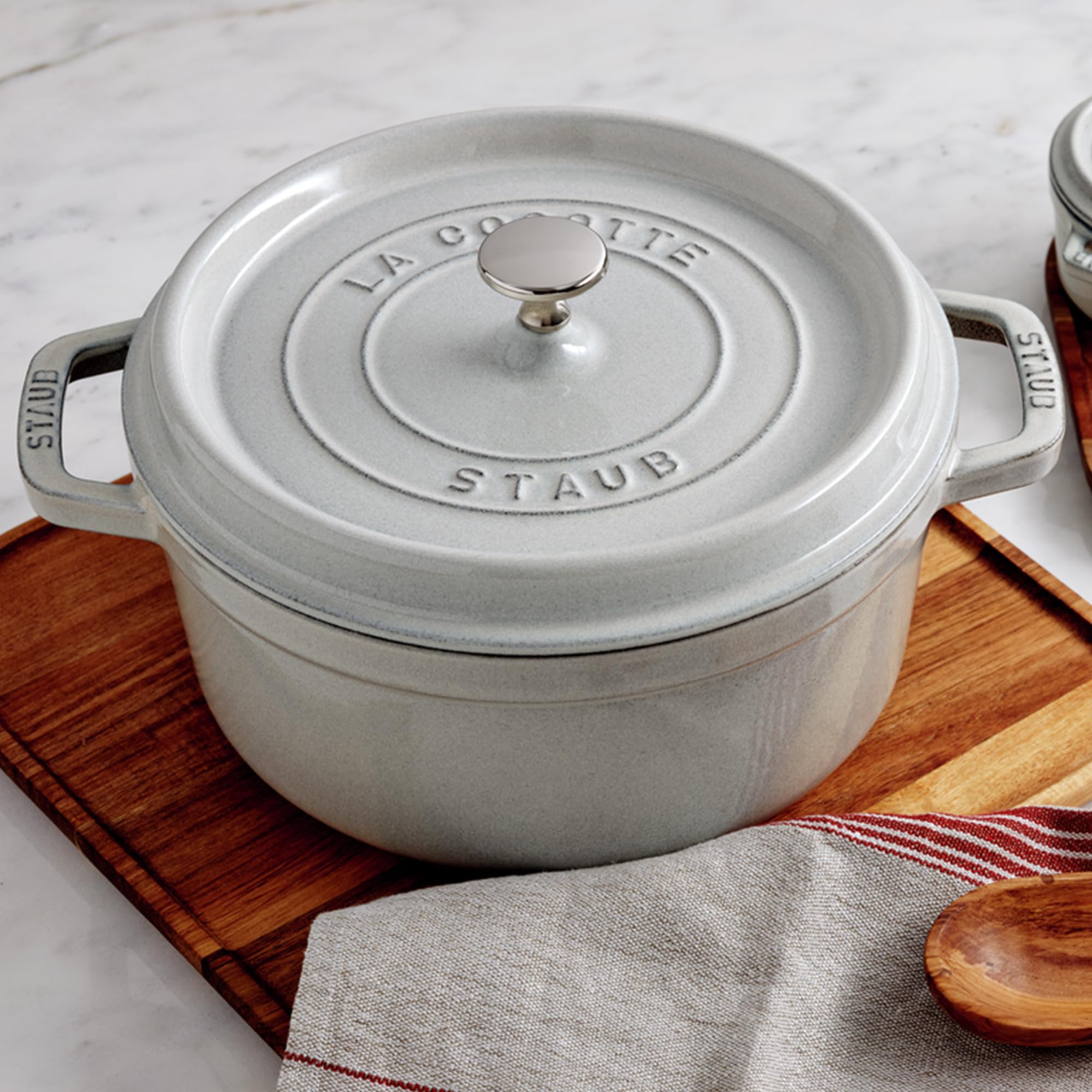 Staub cocotte con interior esmaltado negro mate, primer plano favorece dorado y retención.