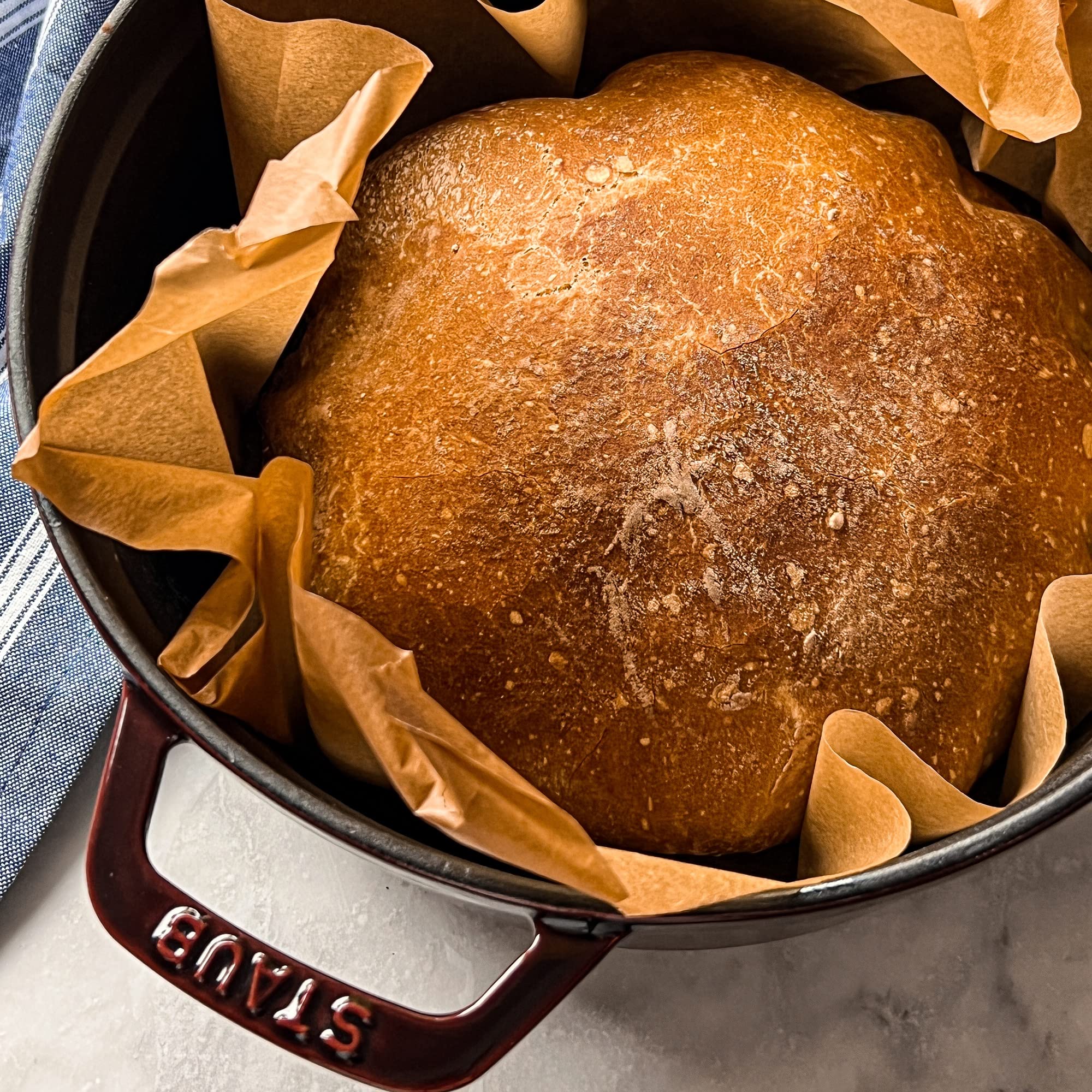 Staub cocotte redonda granate 4qt: tapa con pomo bronce elegante.