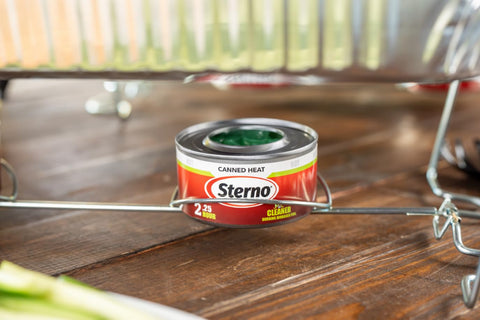 Sterno lata junto a mano para comparar tamaño y portabilidad