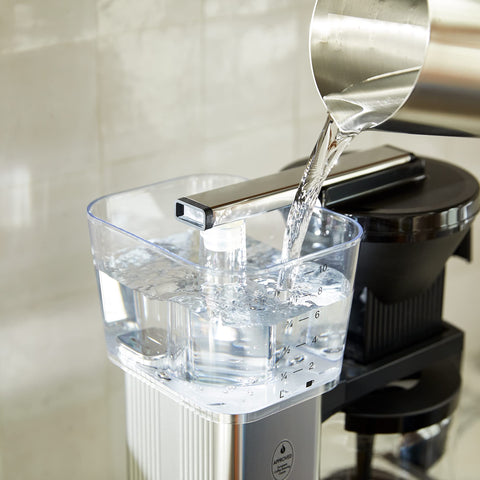 Technivorm Moccamaster cafetera naranja con jarra de vidrio lista para servir.